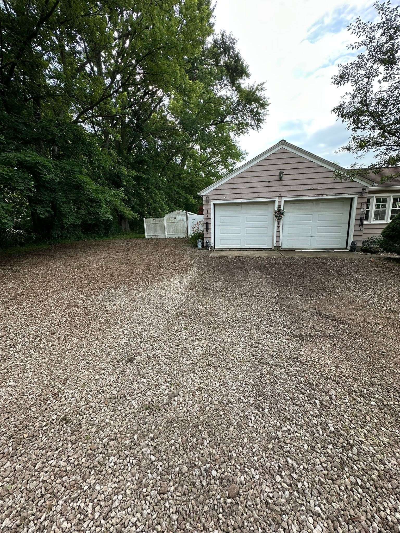 New gravel driveway and parking area installed beside a home