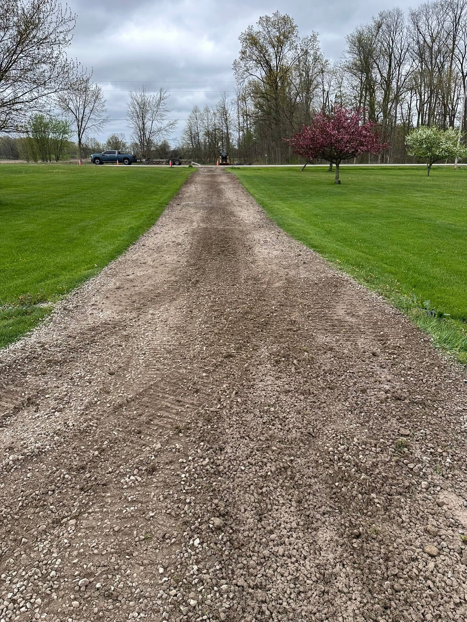 Freshly repaired gravel driveway leading to a roadway