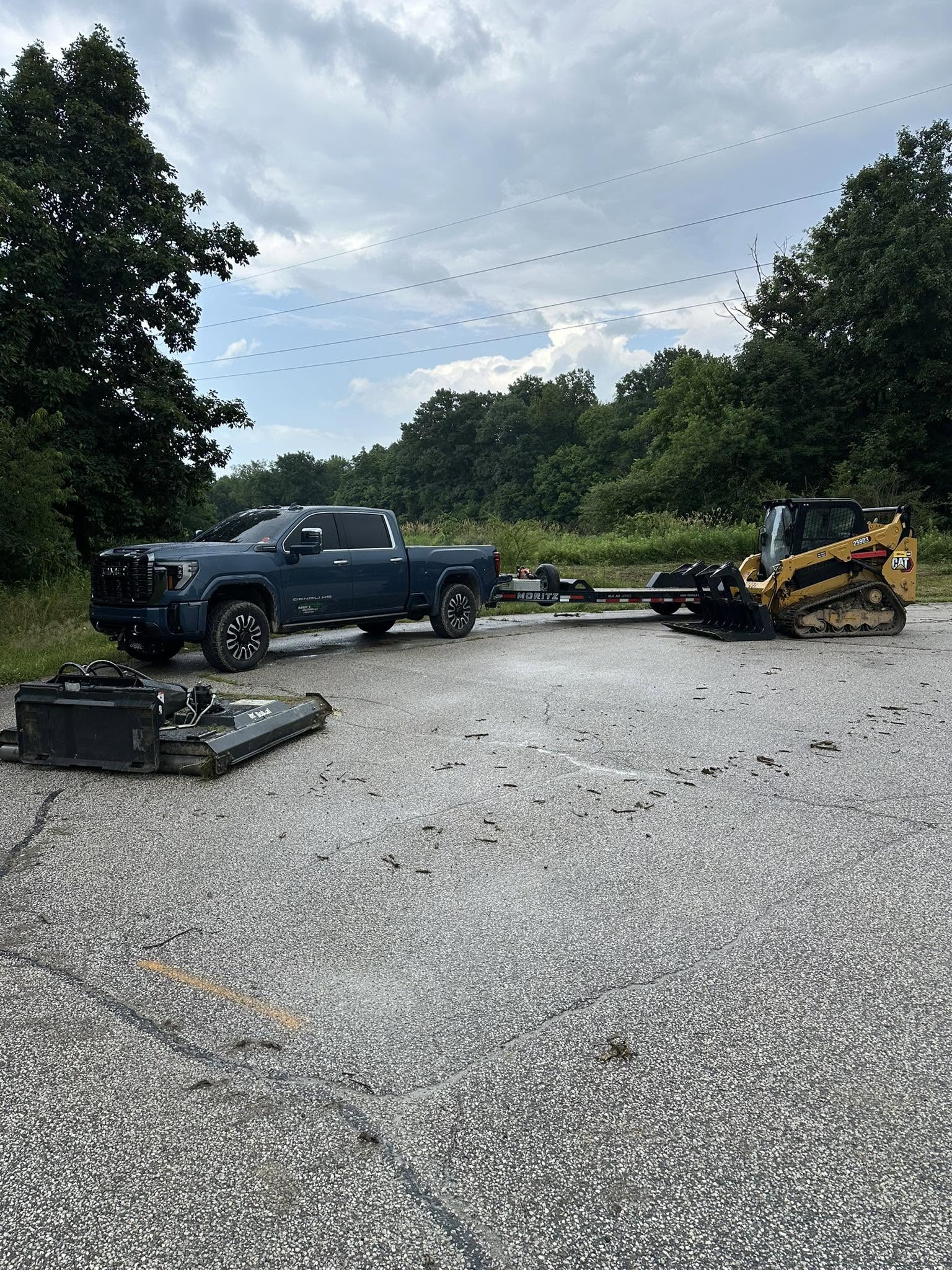 Pickup truck and equipment trailer transporting a tracked skid steer