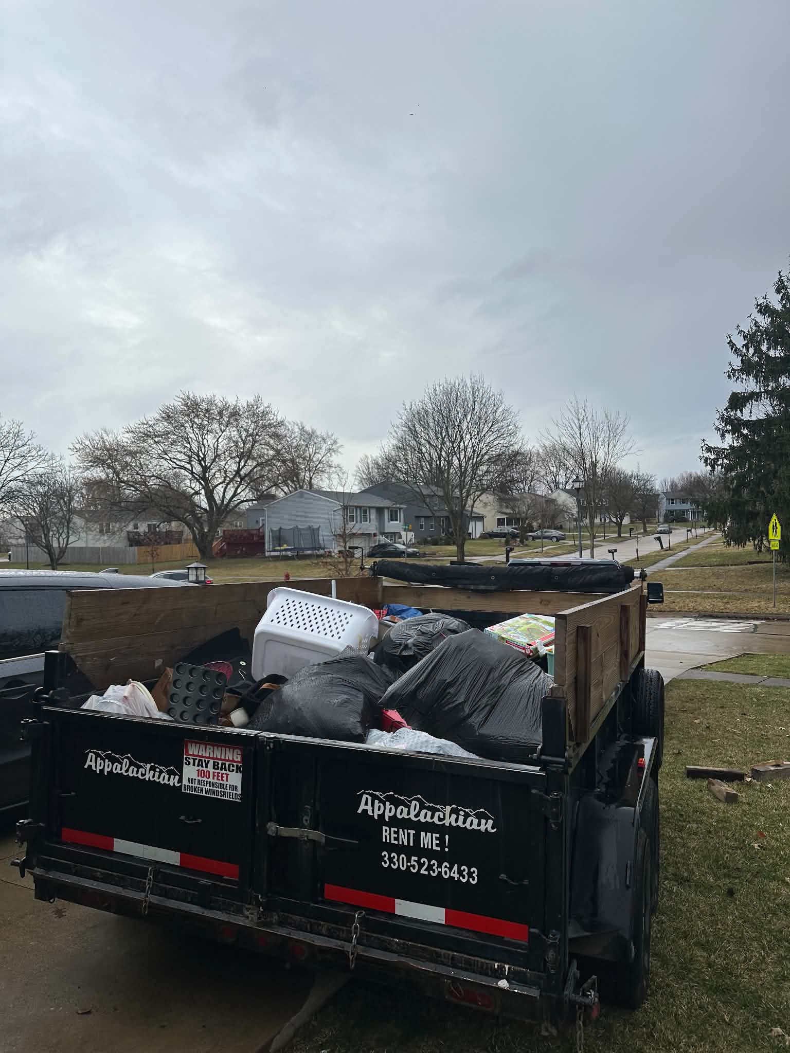 Dump trailer filled with bags and household cleanout debris