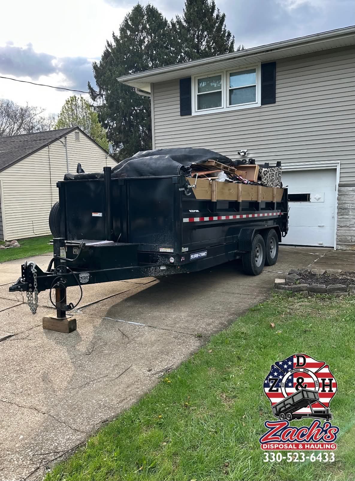 Driveway-safe dump trailer filled during a residential cleanout