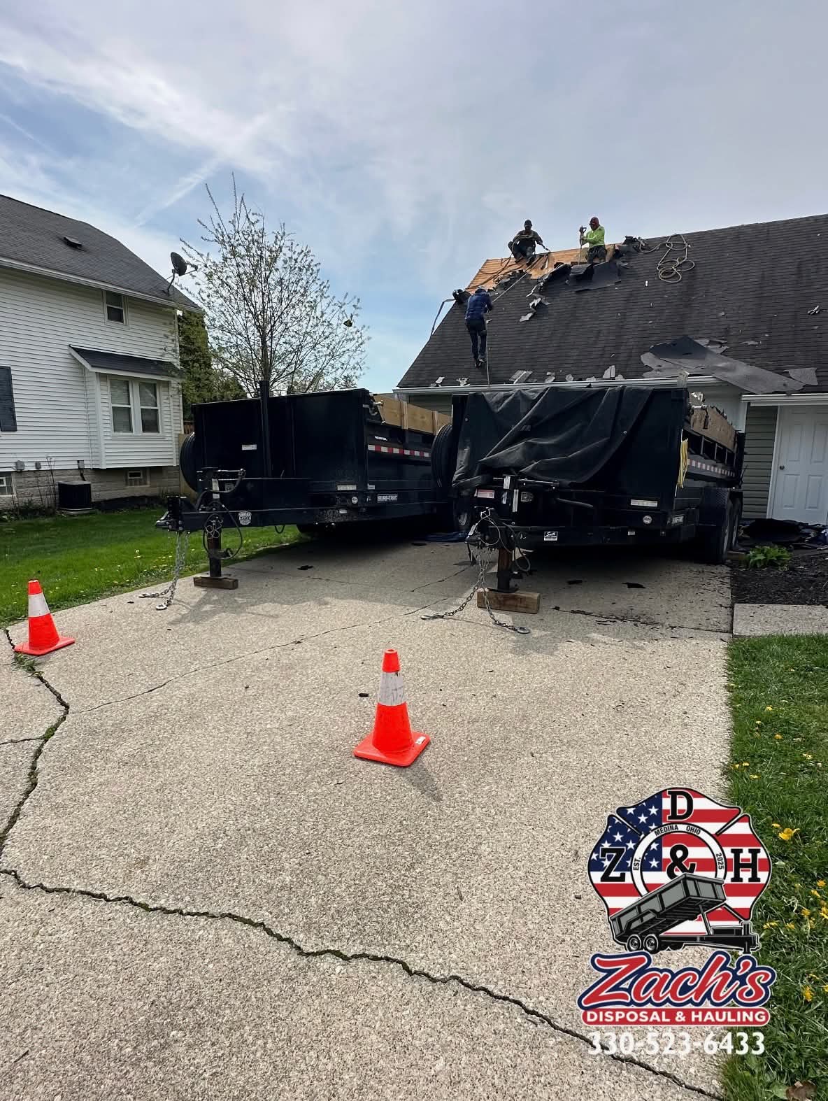 Two dump trailers collecting shingles during a residential roof tear-off