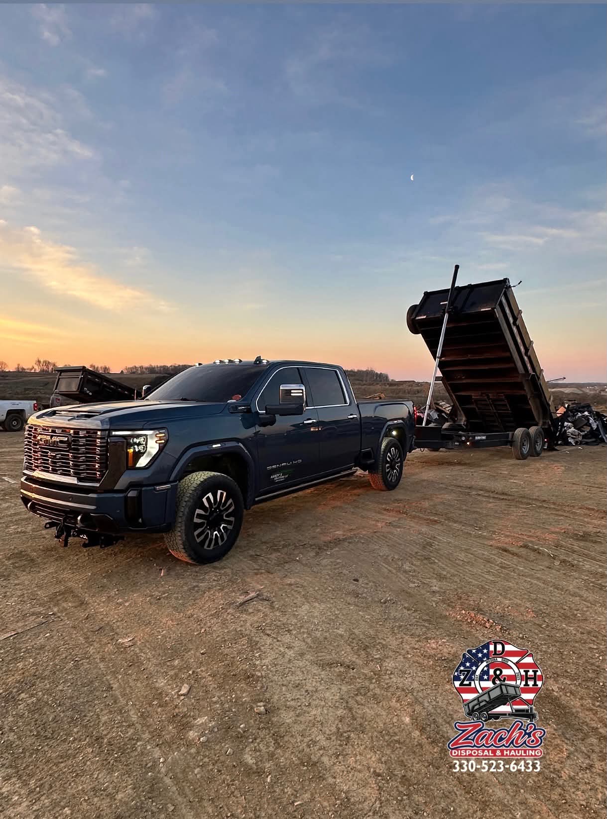 GMC pickup unloading a raised dump trailer at a disposal site