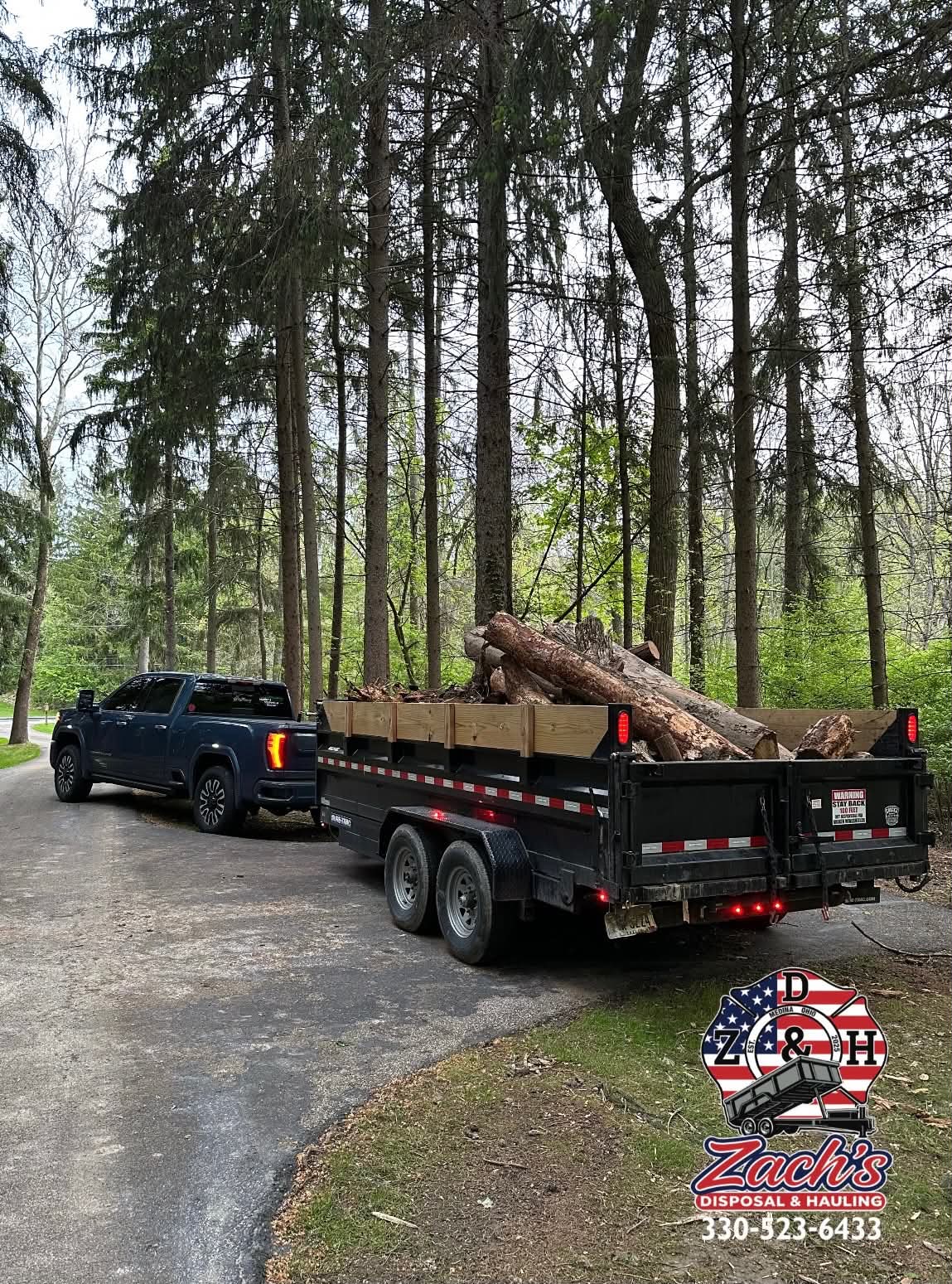 Dump trailer carrying cut tree logs for hauling